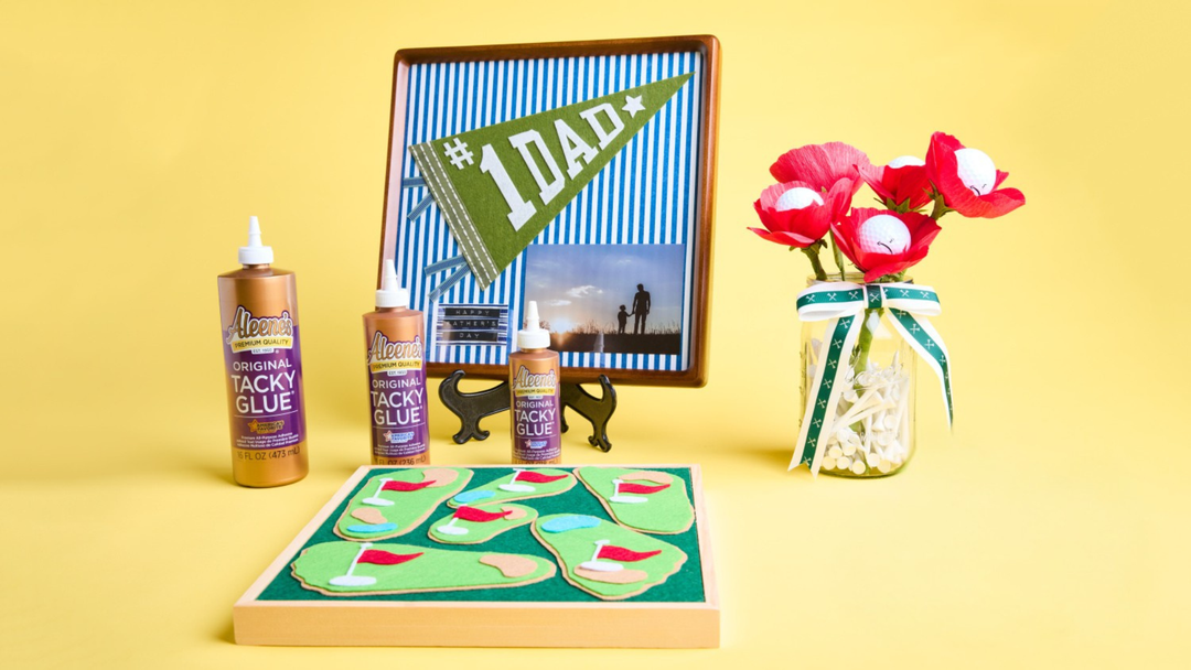Three projects (framed #1 Dad collage, felt golf course and golf ball flowers in jar with golf tees) and three bottles of Tacky Glue in various sizes (tie dye kit & soft paint kit) on yellow background