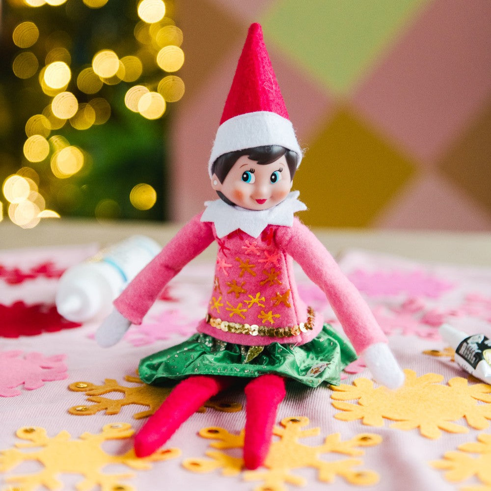 Elf doll in a festive setting with blurred lights and decorations