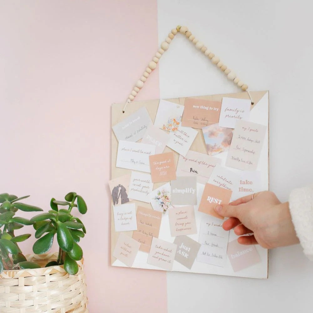 Hanging board with motivational cards on a light pink wall